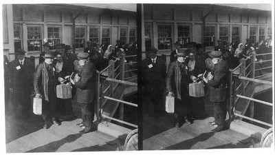Member of the American Bible Society hands out Bibles to emigrants at Ellis Island in New York harbor.