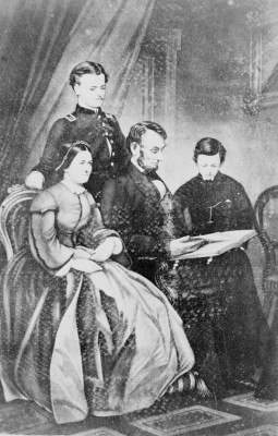 President Lincoln and his family look at a book together.