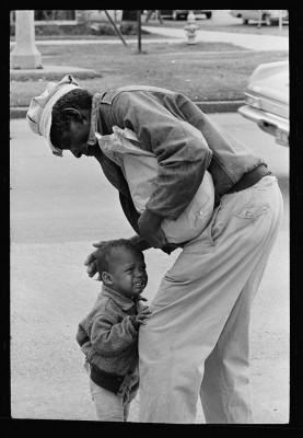 A man comforts a little child in 1962, photo by Toni Frissell, courtesy Library of Congress.