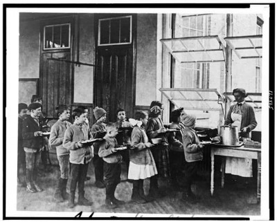 Children line up for lunch at a school in New York, c. 1910. Courtesy Library of Congress.