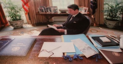 Notice the index cards wrapped in a rubber band beside the president's phone.
